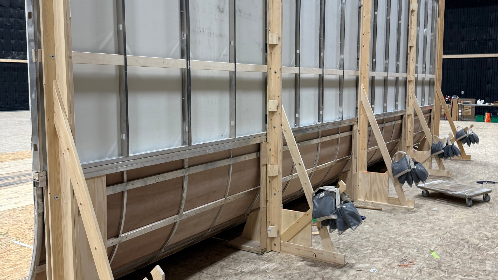 Curved cove wall panels with wooden framework and support braces on soundstage