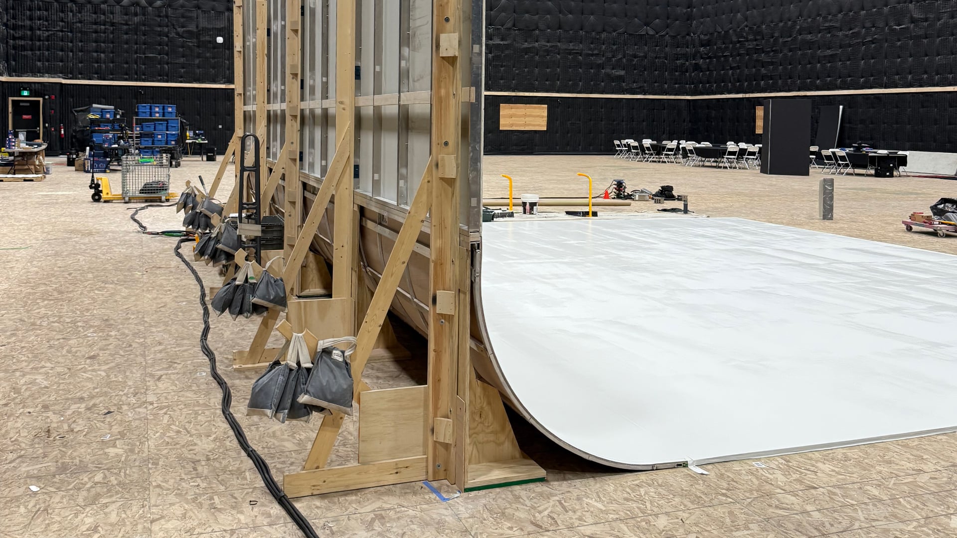 Side view of cove wall showing wooden bracing structure and curved white surface on soundstage