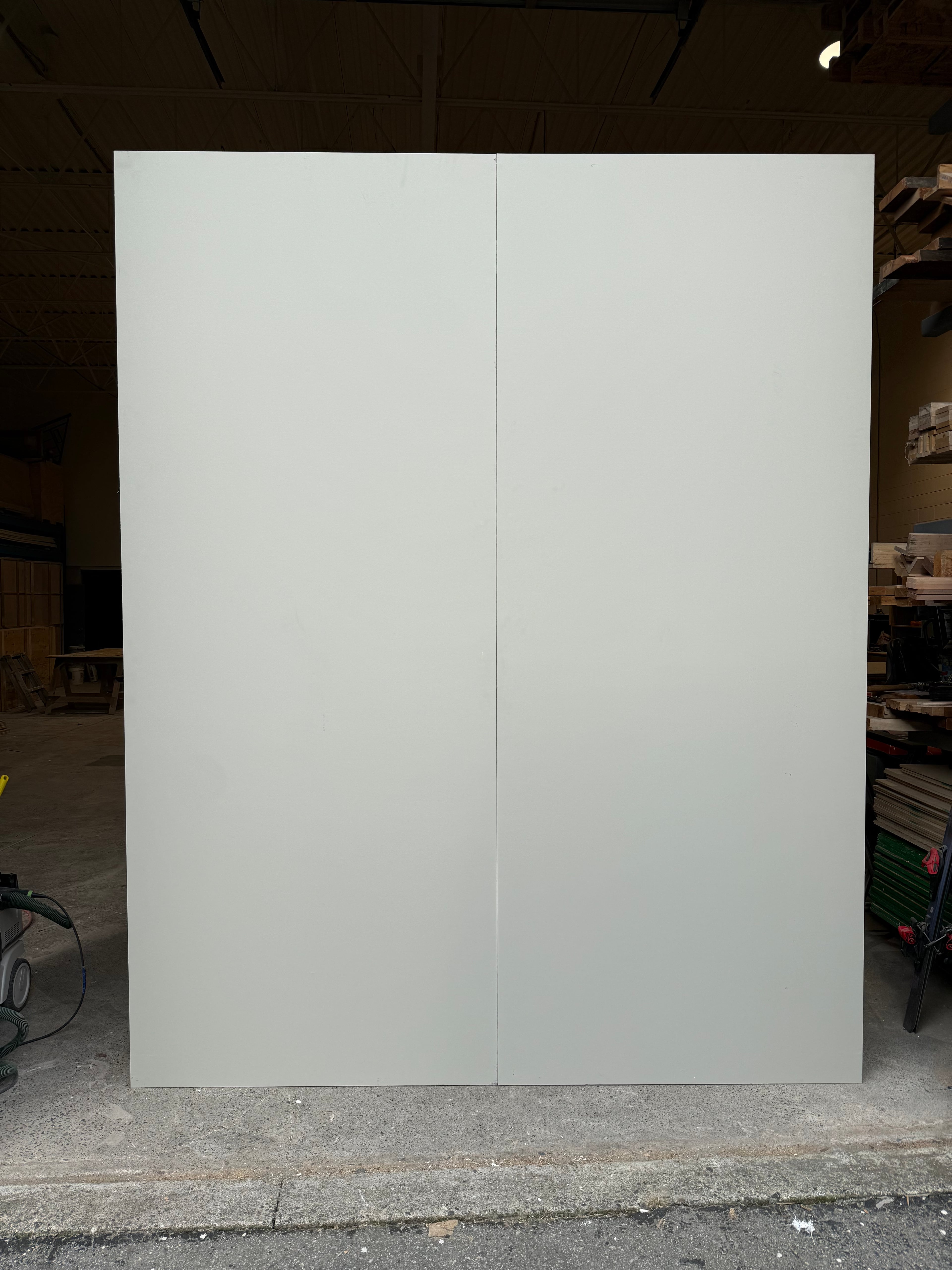 Front view of modular indoor-outdoor wall panel with smooth white surface in workshop