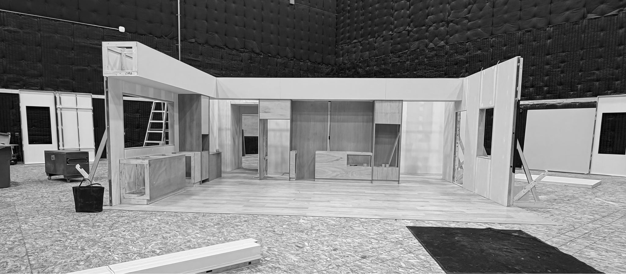 Modern interior set under construction on soundstage with kitchen cabinetry, hardwood floors, and white walls for Bosch commercial