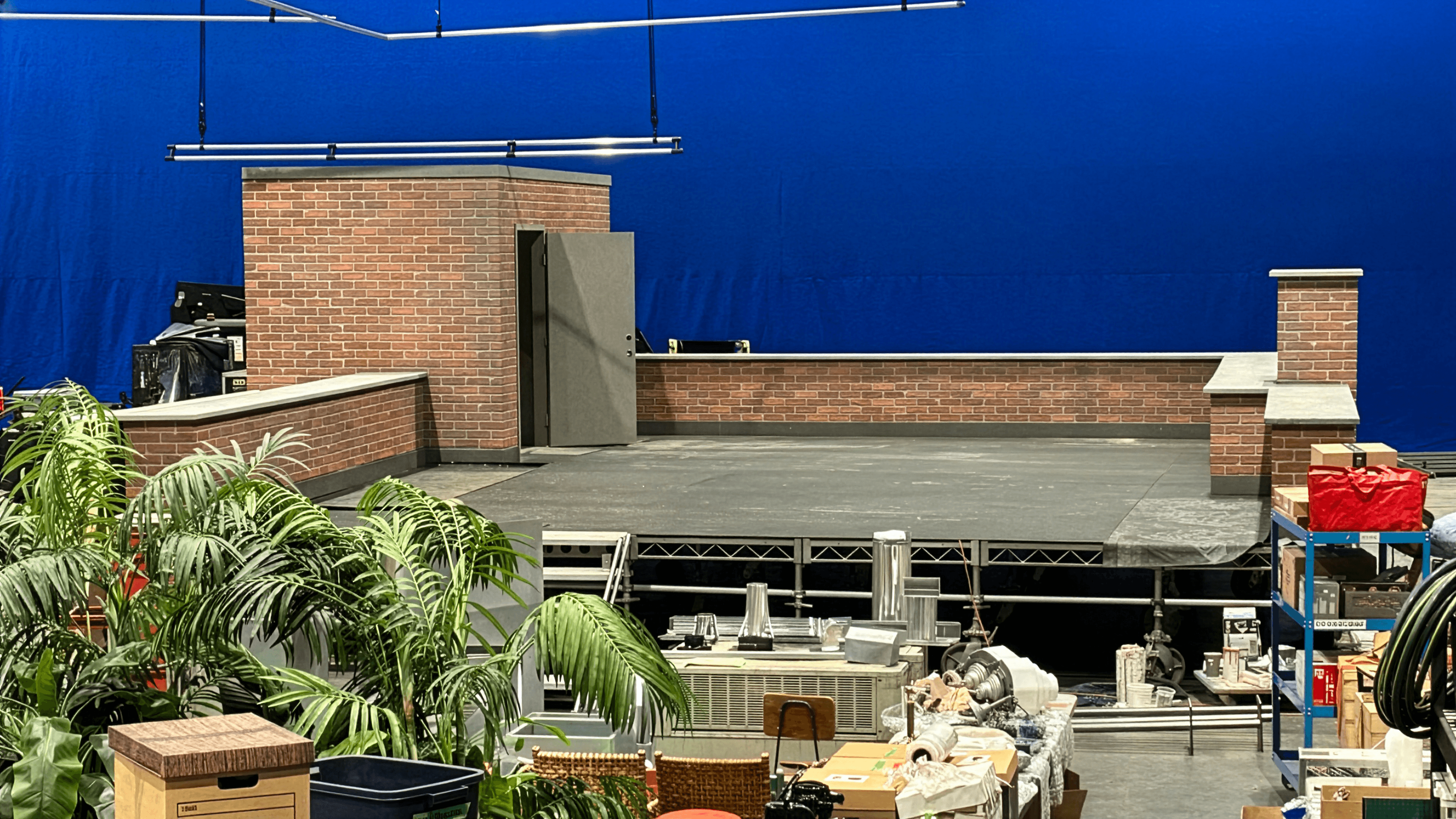 Décor de terrasse sur le toit avec colonnes de briques et plantes tropicales devant un écran bleu pour une publicité Captain Morgan