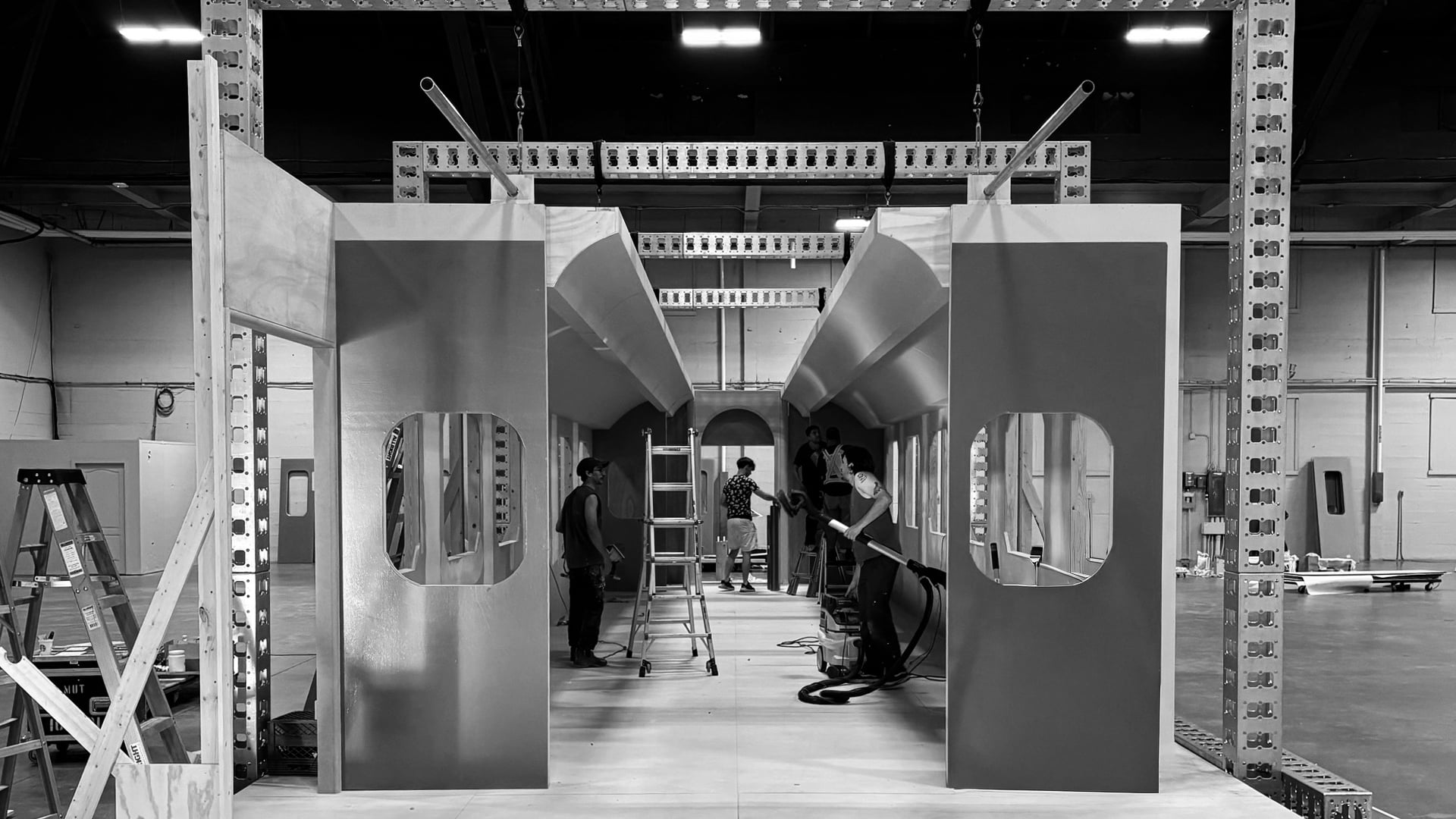 Front entrance view of train cabin set under construction with gold-painted walls and oval windows in warehouse for MGM Grand