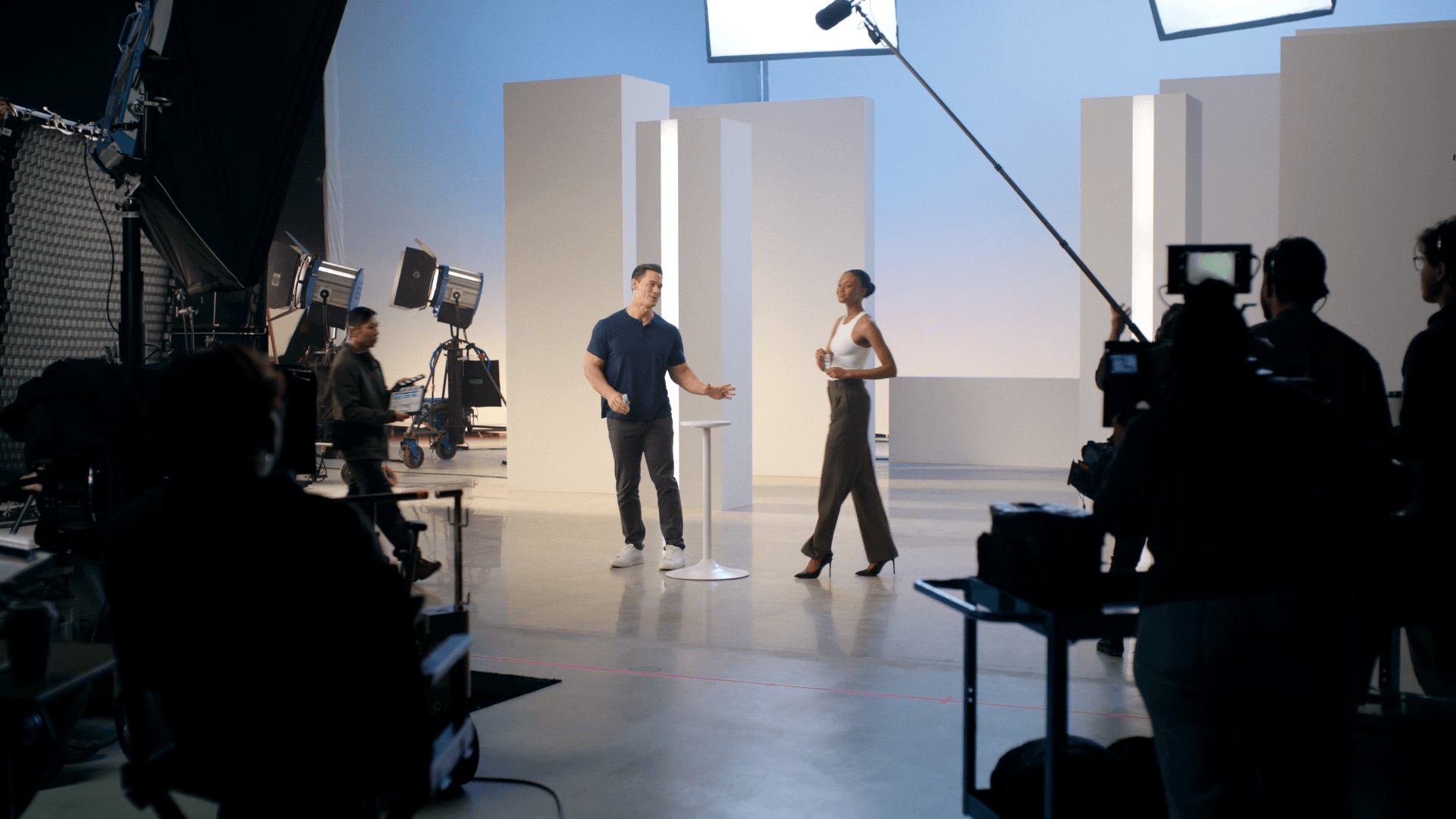 Two actors on a minimal white studio set with modular wall panels during Neutrogena commercial shoot