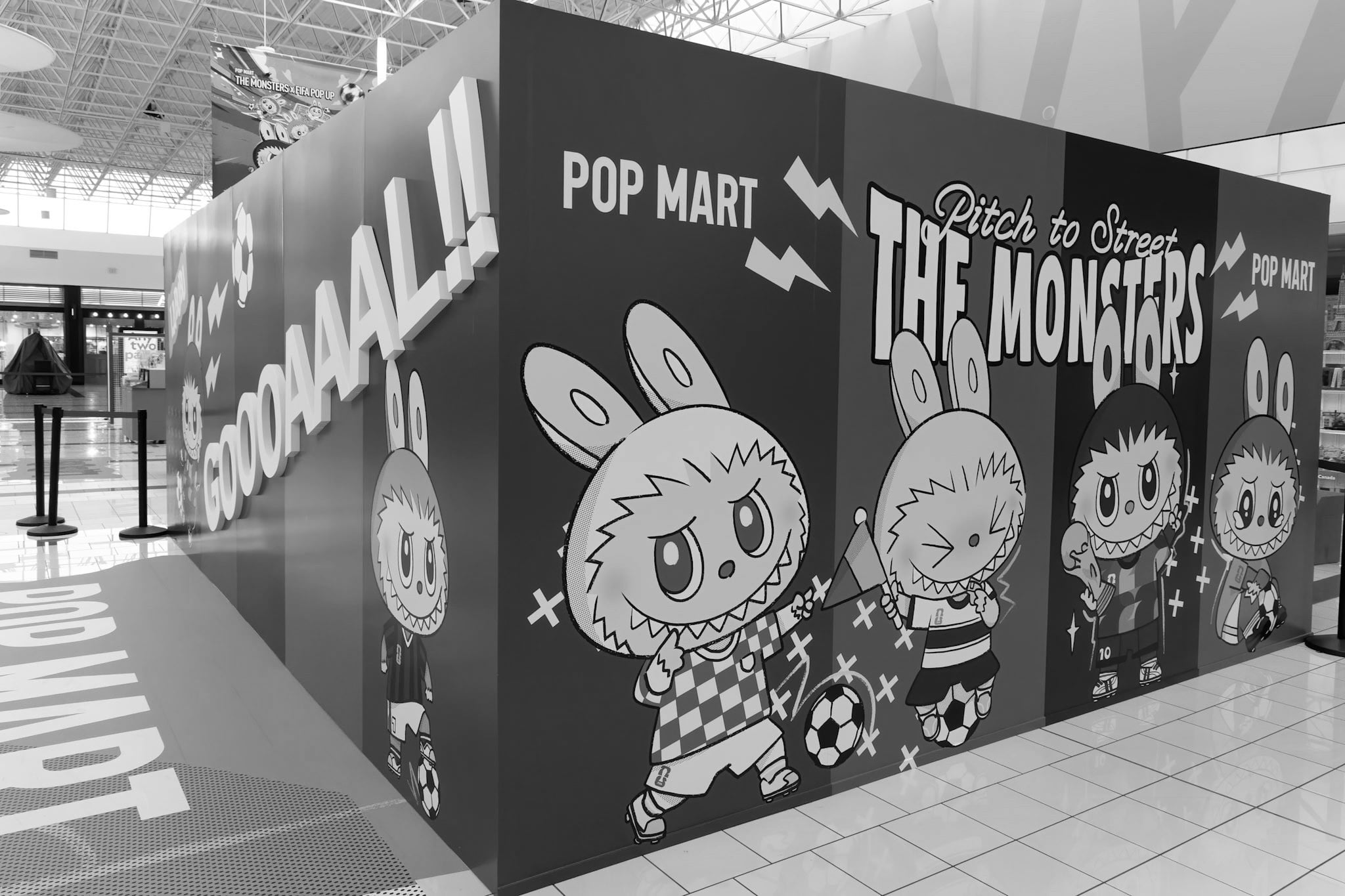 Black-and-white wall graphic reading 'Pitch to Street: The Monsters' with Labubu characters in soccer kits.